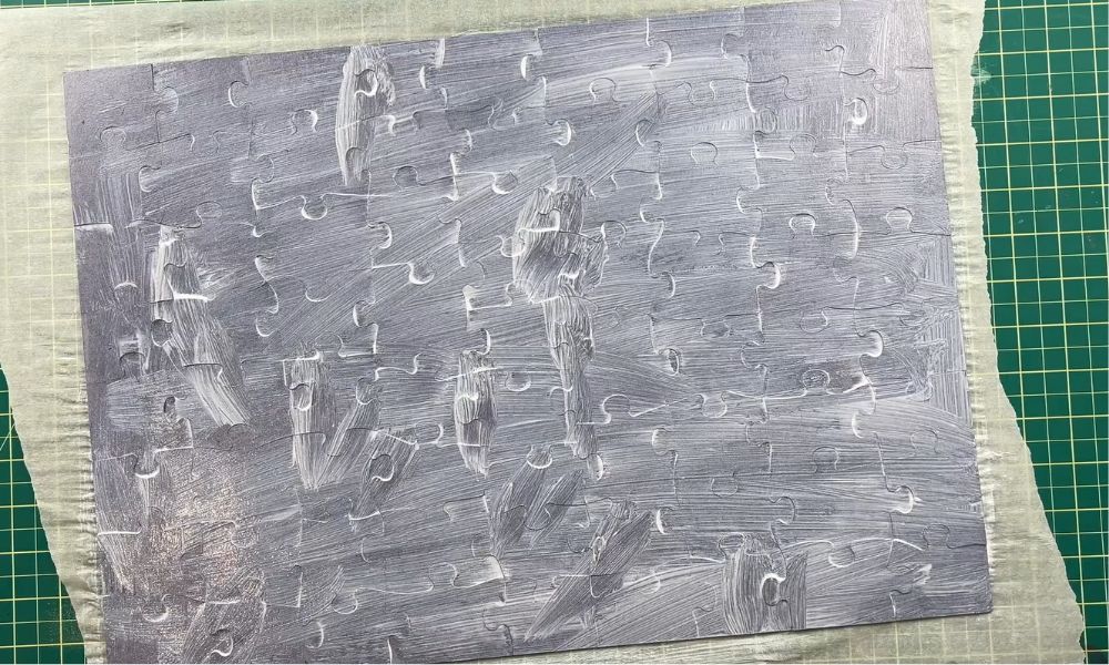 Close-up of a completed jigsaw puzzle covered with visible white puzzle glue and brush marks