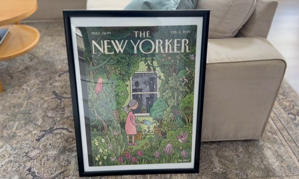 Completed New Yorker cover jigsaw puzzle displayed in a black picture frame with a white mat